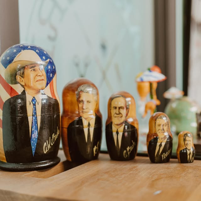 Hand-painted nesting dolls of U.S. presidents on a shelf in the shop