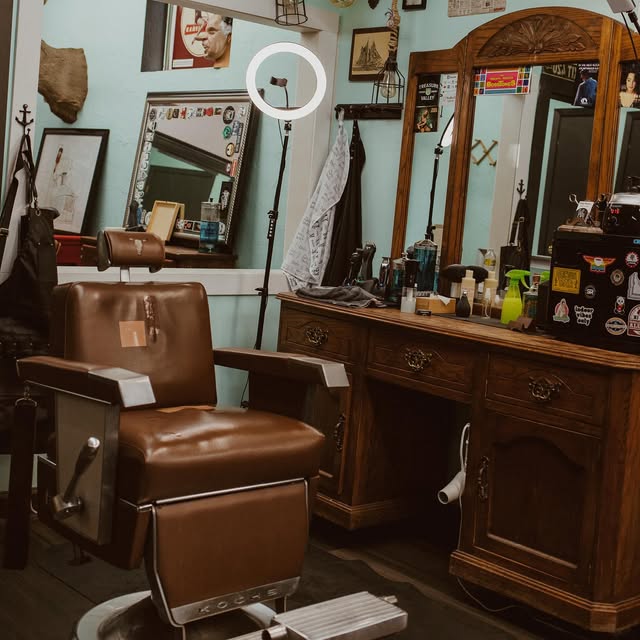 Restored leather barber chair in front of a wooden station