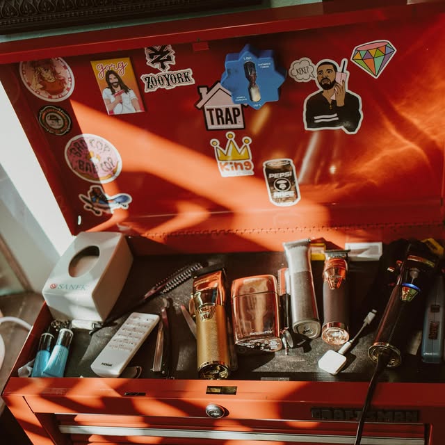 A red toolbox holding a barber's clippers and trimmers