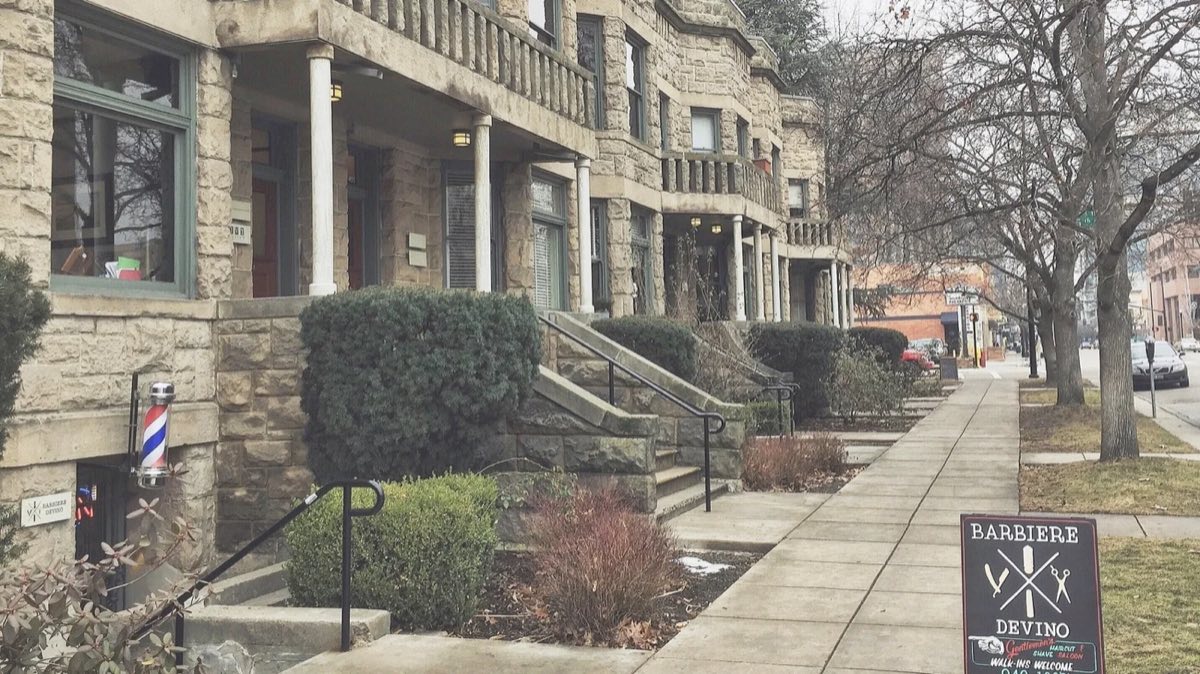 The sandstone row on West Hays Street with the Barbiere DeVino barber pole and walk-ins welcome sign